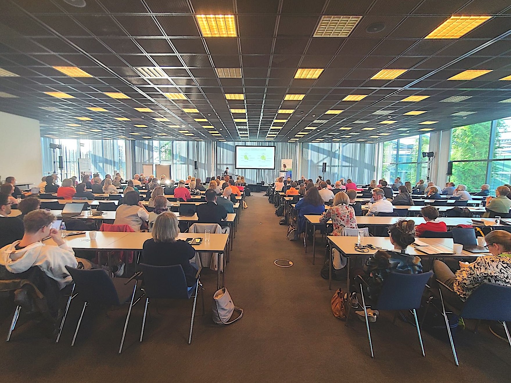 picture taken at the NCT Patient Conference. Taken from the back of the room, it shows the audience and speaker plus screen.